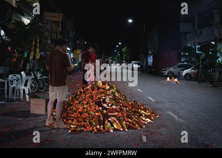 Georgetown, Penang, Malaisie - 29 janvier 2023 : les habitants préparent et brûlent des offrandes dorées et rouges dans la rue pour le nouvel an chinois Banque D'Images