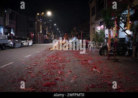 Georgetown, Penang, Malaisie - 29 janvier 2023 : les habitants préparent le feu dans la rue avec des pétards usagés pour le nouvel an chinois Banque D'Images