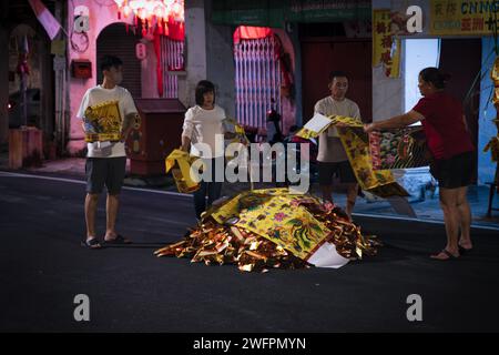 Georgetown, Penang, Malaisie - 29 janvier 2023 : les habitants préparent le feu traditionnel de minuit des offrandes de papier doré dans la rue pour la nouvelle yea chinoise Banque D'Images