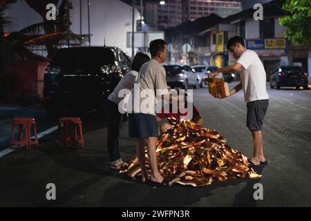 Georgetown, Penang, Malaisie - 29 janvier 2023 : les habitants préparent le feu traditionnel de minuit des offrandes dans la rue pour le nouvel an chinois Banque D'Images