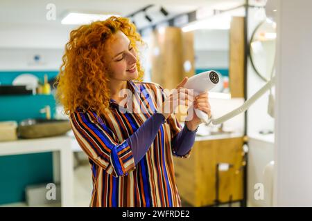 Portrait de l'acheteur dans le magasin de salle de bains. Femme rousse choisit l'équipement pour sa salle de bain. Banque D'Images
