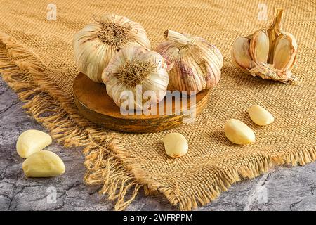 L'ail sur une planche de bois sur un tissu. Banque D'Images