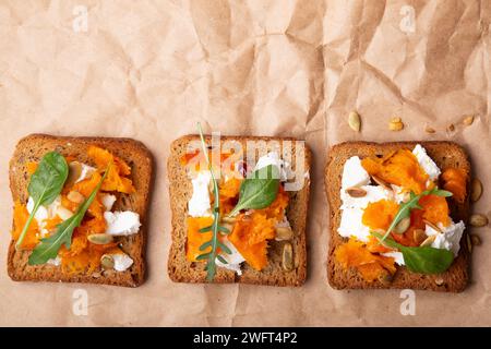 Bruschetta à la citrouille savoureuse avec du fromage feta et une délicate garniture à feuilles. Nourriture rustique réconfortante. Banque D'Images