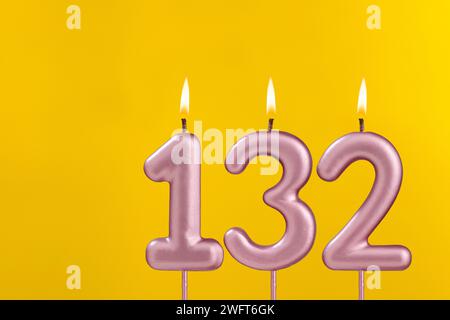 Bougie 132 avec flamme - carte d'anniversaire sur fond jaune de luxe Banque D'Images