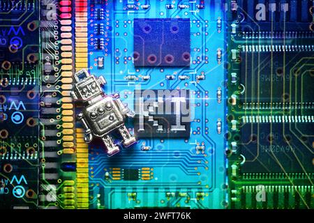 FOTOMONTAGE, Roboterfigur liegt auf Computerplatine mit Aufschrift KI, Symbolfoto künstliche Intelligenz *** PHOTOMONTAGE, figurine de robot posée sur la carte d'ordinateur avec inscription ai, photo symbolique intelligence artificielle Banque D'Images