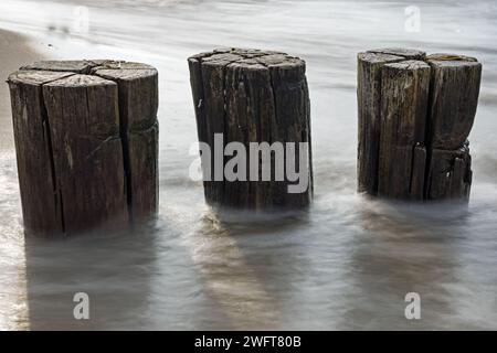 Gros plan de trois groynes en bois dans la mer Baltique avec une longue exposition Banque D'Images