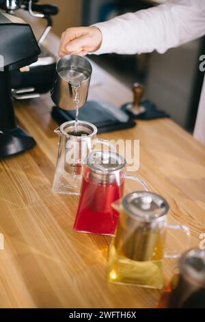 Un jeune barista prépare de délicieux thés dans un café moderne. Banque D'Images