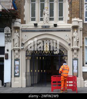 Ouvrier devant l'entrée de servite Catholic Church (Our Lady of Dolours) Chelsea Londres Angleterre Banque D'Images