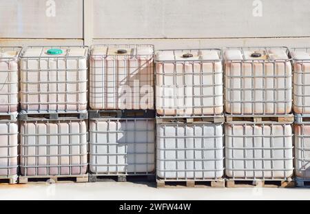 Une pile de conteneurs de fret en rangées à l'usine avec du liquide à l'intérieur Banque D'Images