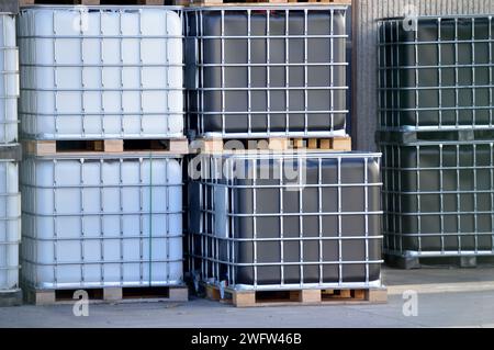 Une pile de conteneurs de fret en rangées à l'usine avec du liquide à l'intérieur Banque D'Images