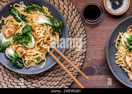 Portions de nouilles lo mein avec porc, bok choy et champignons cremini Banque D'Images