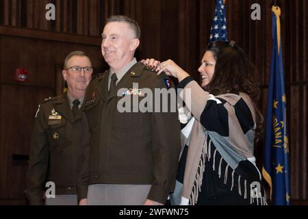 Le major général Dan Degelow, garde nationale de l'Indiana, au centre, reçoit son rang de deux étoiles de sa femme, Lisa, alors que le major général Dale Lyles, à gauche, regarde lors de la cérémonie de promotion de Degelow à Stout Field, samedi 20 janvier 2024. Banque D'Images