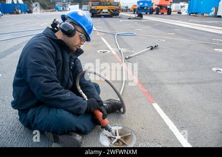 240123-N-UF592-1023 YOKOSUKA, Japon (23 janvier 2024) Aviation Boatswain’s Mate (gestion des avions) l'aviateur Christian Vasquez Cruz, d'Orlando, en Floride, contrôle la corrosion en utilisant un pistolet à aiguille sur le pont d'envol du seul porte-avions déployé à l'avant de la marine américaine, USS Ronald Reagan (CVN 76), tandis que le commandant au port, les activités de la flotte Yokosuka, janv. 23. Ronald Reagan, le navire amiral du Carrier Strike Group 5, fournit une force prête au combat qui protège et défend les États-Unis, et soutient les alliances, les partenariats et les intérêts maritimes collectifs dans le regi Indo-Pacifique Banque D'Images