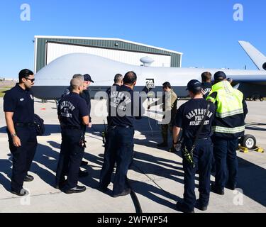 Un membre du 147th Attack Wing Aircraft Maintenance Squadron donne une visite de familiarisation et un briefing aux membres du service d'incendie de Galveston à l'aéroport international Scholes à Galveston, Texas, le 10 janvier 2024. L'escadre a testé des opérations de lancement et de récupération de satellites à l'aéroport international Scholes de Galveston dans le cadre de son approche novatrice du concept d'emploi de combat agile. Banque D'Images