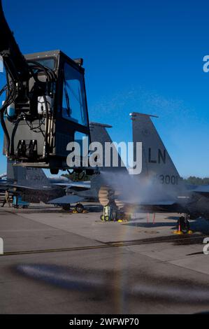 U.S. Airman 1st Class Ryan Johnson, 492nd Fighter Generation Squadron F-15 adjoint chef d'équipage dédié, décore un F-15E Strike Eagle de l'US Air Force affecté au 492nd Fighter Squadron de la RAF Lakenheath, Angleterre, le 18 janvier 2024. Le dégivreur utilise un mélange d'eau chauffée et de liquide de dégivrage pour empêcher la formation future de glace sur l'avion. Banque D'Images
