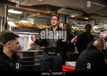 240115-N-VM650-1068 MER DE CHINE MÉRIDIONALE (15 janvier 2024) CDR. Jason Garfield, commandant du destroyer de missiles guidés de classe Arleigh Burke USS Sterett (DDG 104), mène une discussion lors d'un Martin Luther King Jr Fête de la journée sur les ponts de mess. Sterett est affecté au Carrier Strike Group ONE et déployé dans la zone d'opérations de la 7e flotte américaine en soutien à un Indo-Pacifique libre et ouvert. Banque D'Images