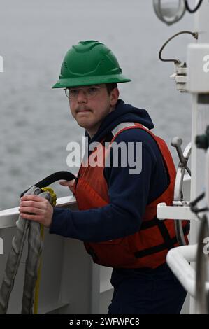 Le quartier-maître de 3rd Class Joshua Altman, un manutentionnaire de ligne à bord de l'USCGC Lawrence Lawson, avance en simulant la ligne deux lors d'une évolution d'amarrage, le 16 janvier 2024, à Cape May, New Jersey. Le Cutter d'intervention rapide de la Garde côtière (FRC) excelle dans diverses missions telles que la sécurité des ports, des voies navigables et des côtes, la conduite de patrouilles de pêche, l'exécution d'opérations de recherche et de sauvetage et la contribution à la défense nationale. Banque D'Images