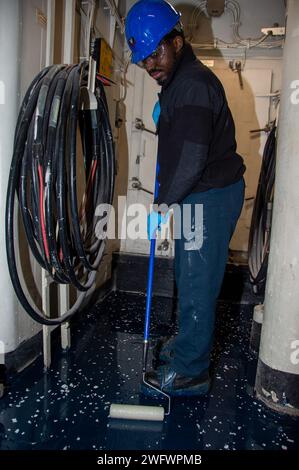 YOKOSUKA, Japon (10 janvier 2024) Aviation Boatswain’s Mate (Handling) 3rd Class Kendel Kinsey, de Loganville, Géorgie, étale de l’époxy transparent tout en appliquant un composé polyrésine sur le pont à bord du seul porte-avions déployé à l’avant de l’US Navy, USS Ronald Reagan (CVN 76), alors qu’il était au port Commander, Fleet Yokosuka, Fleet Yokosuka, janvier 10. Ronald Reagan, le navire amiral du Carrier Strike Group 5, fournit une force prête au combat qui protège et défend les États-Unis, et soutient les alliances, les partenariats et les intérêts maritimes collectifs dans la région Indo-Pacifique. Banque D'Images