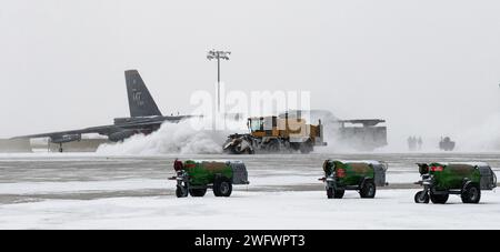 Des aviateurs du 5th civil Engineer Squadron déneigent la neige à l’aide d’un chasse-neige sur la ligne de vol au cours de l’exercice Prairie vigilance/Bayou vigilance 24-2 (PV/BV) à la base aérienne de Minot, Dakota du Nord, le 7 janvier 2024. La résilience, la compétitivité, l’innovation et l’amélioration des processus sont autant de compétences que PV/BV promeut pour relever les défis actuels. Banque D'Images