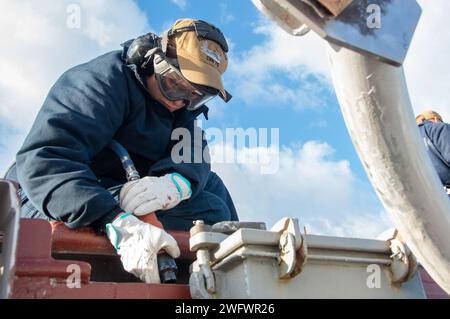 YOKOSUKA, Japon (5 janvier 2024) l’aviateur Alexa Flores, originaire de Corpus Christi, Texas, utilise un pistolet à aiguille pour préserver le pont d’envol du seul porte-avions déployé à l’avant de la marine américaine, l’USS Ronald Reagan (CVN 76), alors qu’il était commandant au port, Fleet Activities Yokosuka, janvier 5. Ronald Reagan, le navire amiral du Carrier Strike Group 5, fournit une force prête au combat qui protège et défend les États-Unis, et soutient les alliances, les partenariats et les intérêts maritimes collectifs dans la région Indo-Pacifique. Banque D'Images