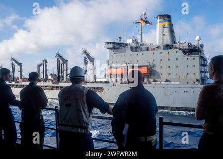 PHILIPPINES SEA (20 janvier 2024) les marins affectés au porte-avions amphibie USS America (LHA 6), observent le ravitailleur de la flotte USNS John Ericsson (T-AO-194) opérant aux côtés de l'Amérique lors d'un réapprovisionnement en mer alors qu'ils naviguaient dans la mer des Philippines, janvier 20. America, navire de tête de l'America Amphibious Ready Group, opère dans la zone d'opérations de la 7e flotte américaine. La 7e flotte américaine est la plus grande flotte numérotée déployée à l’avant de la marine américaine. Elle interagit et opère régulièrement avec des alliés et des partenaires pour préserver une région Indo-Pacifique libre et ouverte. Banque D'Images