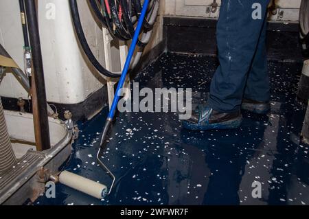 YOKOSUKA, Japon (10 janvier 2024) Aviation Boatswain’s Mate (Handling) 3rd Class Kendel Kinsey, de Loganville, Géorgie, étale de l’époxy transparent tout en appliquant un composé polyrésine sur le pont à bord du seul porte-avions déployé à l’avant de l’US Navy, USS Ronald Reagan (CVN 76), alors qu’il était au port Commander, Fleet Yokosuka, Fleet Yokosuka, janvier 10. Ronald Reagan, le navire amiral du Carrier Strike Group 5, fournit une force prête au combat qui protège et défend les États-Unis, et soutient les alliances, les partenariats et les intérêts maritimes collectifs dans la région Indo-Pacifique. Banque D'Images