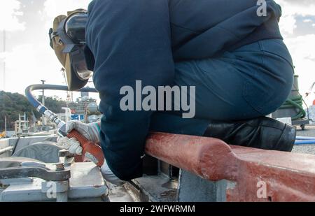 YOKOSUKA, Japon (5 janvier 2024) l’aviateur Alexa Flores, originaire de Corpus Christi, Texas, utilise un pistolet à aiguille pour préserver le pont d’envol du seul porte-avions déployé à l’avant de la marine américaine, l’USS Ronald Reagan (CVN 76), alors qu’il était commandant au port, Fleet Activities Yokosuka, janvier 5. Ronald Reagan, le navire amiral du Carrier Strike Group 5, fournit une force prête au combat qui protège et défend les États-Unis, et soutient les alliances, les partenariats et les intérêts maritimes collectifs dans la région Indo-Pacifique. Banque D'Images