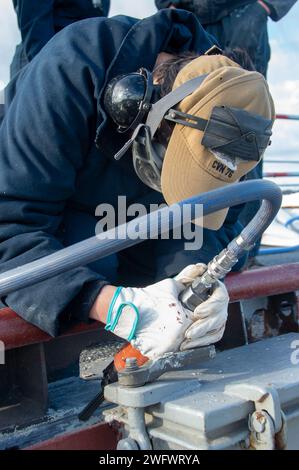 YOKOSUKA, Japon (5 janvier 2024) l’aviateur Alexa Flores, originaire de Corpus Christi, Texas, utilise un pistolet à aiguille pour préserver le pont d’envol du seul porte-avions déployé à l’avant de la marine américaine, l’USS Ronald Reagan (CVN 76), alors qu’il était commandant au port, Fleet Activities Yokosuka, janvier 5. Ronald Reagan, le navire amiral du Carrier Strike Group 5, fournit une force prête au combat qui protège et défend les États-Unis, et soutient les alliances, les partenariats et les intérêts maritimes collectifs dans la région Indo-Pacifique. Banque D'Images