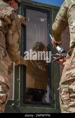 L'aviateur supérieur de l'US Air Force Conor Mills, à gauche, et le sergent d'état-major Treaon Sterling, techniciens en radar, aérodrome et systèmes météorologiques du 409th Air Expeditionary Group, sécurisent une nouvelle fenêtre sur une tour de contrôle mobile MSN-7 à la base aérienne 201, le 8 janvier 2024. Une tour de contrôle mobile peut être utilisée dans des environnements d'urgence, entièrement configurée et capable de contrôler l'espace aérien en moins de deux heures. Banque D'Images