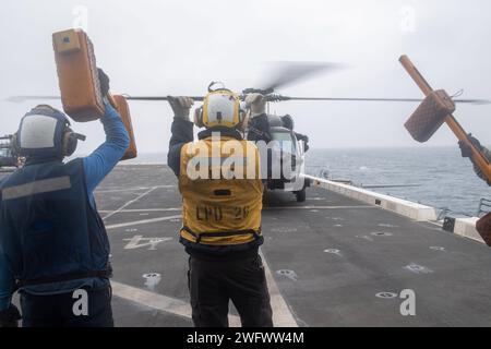Aviation Boatswain’s Mate (Handling) 3rd Class Jonathan Patito, affecté au navire amphibie de transport à quai USS John P. Murtha (LPD 26), signale à un pilote d’hélicoptère MH-60M Blackhawk, affecté au 160th Special Operations Aviation Regiment (Airborne), cette craie et ces chaînes ont été enlevées de l'avion sur le poste d'envol de l'opération POLAR DAGGER, le 2 septembre 2023. Les navires de transport amphibies comme John P. Murtha ont de nombreuses capacités uniques qui en font des plates-formes idéales pour soutenir les forces d'opérations spéciales, telles que la capacité d'embarquer des hélicoptères de la force conjointe, de lancer et de RE Banque D'Images