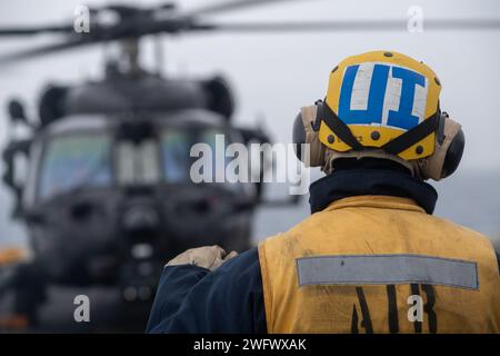 Aviation Boatswain’s Mate (Handling) l’aviateur Christopher Torres, affecté au quai de transport amphibie USS San Diego (LPD 22), sgnals à un hélicoptère MH-60M Blackhawk, affecté au 160th Special Operations Aviation Regiment (Airborne), sur le pont d’envol du quai de transport amphibie USS John P. Murtha (LPD 26) pendant l'opération POLAR DAGGER, le 2 septembre 2023. Les navires de transport amphibies comme John P. Murtha ont de nombreuses capacités uniques qui en font des plates-formes idéales pour soutenir les forces d'opérations spéciales, telles que la capacité d'embarquer des hélicoptères de la force conjointe, de lancer et de récupérer Banque D'Images