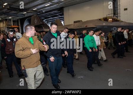 240124-N-ED228-1006 OCÉAN PACIFIQUE (24 janvier 2024) des marins effectuent une promenade de débris de corps étrangers dans la baie du hangar à bord du porte-avions de classe Nimitz USS Abraham Lincoln (CVN 72). Le Abraham Lincoln Carrier Strike Group est en cours dans la zone d'opérations de la 3e flotte américaine, menant un entraînement tactique avancé qui augmente la capacité de combat et la compétence tactique dans tous les domaines. Banque D'Images