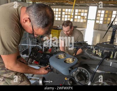 Tech. Sgt clair James, à gauche, technicien en systèmes électriques et environnementaux du 920e Escadron de maintenance des aéronefs, et Tech. Le sergent Jeremy Ellison, chef d'équipage du 920th AMXS, utilise un outil de cintrage de broche pour accéder à une broche en vue de la dépose de la tête de rotor principal d'un hélicoptère HH-60G Pave Hawk à l'intérieur d'un hangar de maintenance à la Patrick Space Force base, Floride, le 3 janvier 2024. Ces broches remplaceront celles corrodées sur un autre Pave Hawk. Les broches sont retirées de ce Pave Hawk parce qu'il est prévu de le retirer au 309th Aerospace Maintenance and Regeneration Group en Arizona plus tard Banque D'Images