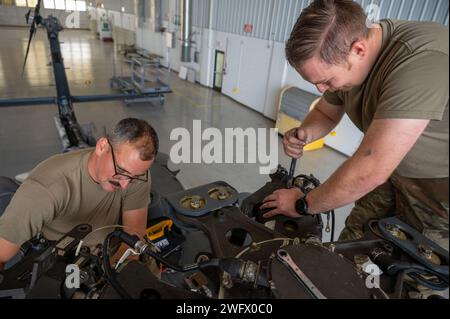 Tech. Sgt clair James, technicien en systèmes électriques et environnementaux du 920e Escadron de maintenance des aéronefs, et Tech. Le sergent Jeremy Ellison, chef d'équipage du 920th AMXS, retire les axes de la tête du rotor principal d'un hélicoptère HH-60G Pave Hawk à l'intérieur d'un hangar de maintenance à la Patrick Space Force base, en Floride, le 3 janvier 2024. Ces broches remplaceront celles corrodées sur un autre Pave Hawk. Les axes sont retirés de ce Pave Hawk parce qu'il est prévu de le retirer au 309th Aerospace Maintenance and Regeneration Group en Arizona plus tard ce mois-ci, marquant le début de la conversion de l'aile Banque D'Images