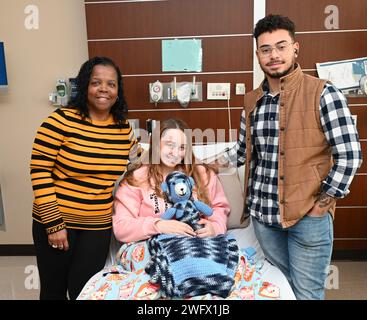 Brenda Ploof, coordonnatrice de l’éducation hospitalière, CRDAMC, présente aux fiers parents et vétérans Alexa et Douglas Davis une couverture d’entrejambe et un ours en peluche qu’elle a confectionnés pour bébé chance Lee, le premier bébé de la nouvelle année à l’accouchement au Carl R. Darnall Army Medical Center. Banque D'Images