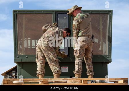 L'aviateur principal de l'US Air Force Conor Mills, à gauche, et le sergent d'état-major Eric Fields, techniciens en radar, aérodrome et systèmes météorologiques du 409th Air Expeditionary Group, installent une nouvelle fenêtre sur une tour de contrôle mobile MSN-7 pour assurer la visibilité de l'aérodrome de la base aérienne 201, Niger, le 8 janvier 2024. L'équipe RAWS est de garde 24 heures sur 24 pour permettre le transport aérien et les missions de renseignement, de surveillance et de reconnaissance afin de protéger les forces américaines opérant dans la région. Banque D'Images