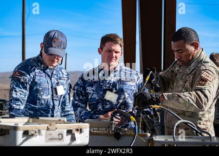 L'avionneur Luke Mather, à gauche, le caporal Matthew Parsell, au milieu, et l'US Air Force Tech. Le sergent Billy Smith affecté au 31e escadron de munitions à la base aérienne d'Aviano (AFB), effectue un auto-test de l'équipement commun de reprogrammation intégré aux munitions avant de tester les queues de bombes à la base aérienne de Nellis, Nevada, le 18 janvier 2024. Une fois testée et construite, la bombe sera prise et chargée sur un avion de combat F-35 Lightning II. (Cette photo a été modifiée pour des raisons de sécurité en brouillant le badge d'identification) Banque D'Images