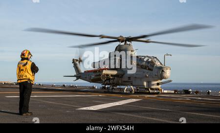 US Navy Aviation Boatswain’s Mate (Handling) de 2e classe Ana Lozano, affecté au navire d’assaut amphibie USS Boxer (LHD 4) et natif de San Antonio, signale un corps des Marines AH-1Z Viper attaché au Marine Medium Tiltrotor Squadron (VMM) 165 (renforcé), 15e Marine Expeditionary Unit, avant le décollage du poste d'envol du Boxer dans l'océan Pacifique, le 6 janvier 2024. Le 15th MEU est actuellement embarqué à bord du Boxer Amphibious Ready Group menant des opérations de formation et de routine intégrées dans la 3rd Fleet américaine. Banque D'Images