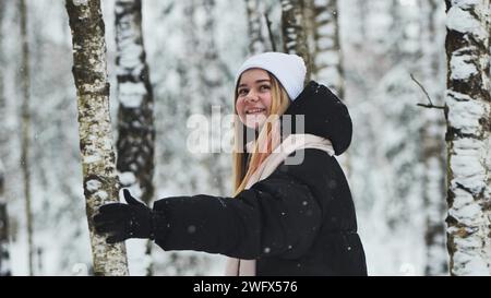 Une fille marchant dans la forêt en hiver parmi les bouleaux. Banque D'Images