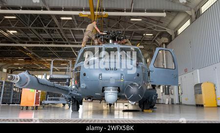 Des aviateurs du 920th Aircraft Maintenance Squadron retirent des axes de la tête de rotor principal d'un hélicoptère HH-60G Pave Hawk à l'intérieur d'un hangar de maintenance à la Patrick Space Force base, Floride, le 3 janvier 2024. Ces broches remplaceront celles corrodées sur un autre Pave Hawk. Les axes sont retirés de ce Pave Hawk parce qu'il est prévu de le retirer au 309th Aerospace Maintenance and Regeneration Group en Arizona plus tard ce mois-ci, marquant le début de la conversion de l'aile au nouveau HH-60W Pave Hawk. Banque D'Images