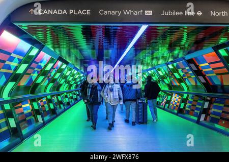 Captivé par les œuvres en couleur de Camille Walala dans Adams Plaza Bridge, Canary Wharf, Londres, Angleterre, Royaume-Uni, avec des gens marchant dans le tunnel Banque D'Images