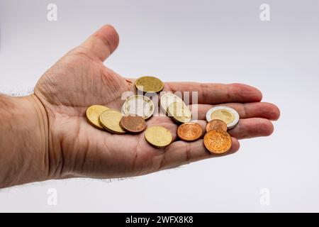 Le dernier argent est quelques pièces en euros dans la main, coupées dans le studio sur fond blanc Banque D'Images