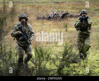 Les soldats de la Garde nationale de Washington avec la compagnie Bravo, 3e bataillon, 161e régiment d'infanterie, équipe de combat de la 81e brigade Stryker, réagissent au contact pendant l'entraînement de l'escouade, sur la base interarmées Lewis-McChord, Washington, le 6 janvier 2024. En pratiquant l’excellence dans les bases, les fantassins sont prêts pour toute mission, locale ou étrangère. Banque D'Images