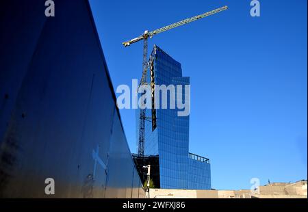 Vilnius (Lituanie) - gratte-ciel en verre moderne en construction. Angle de tir inhabituel. Ciel dégagé, reflets dans les fenêtres Banque D'Images