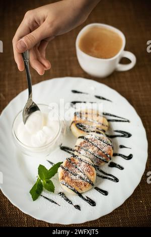 Crêpes avec de la crème glacée et du chocolat sur une assiette blanche sur une table en bois en gros plan Banque D'Images