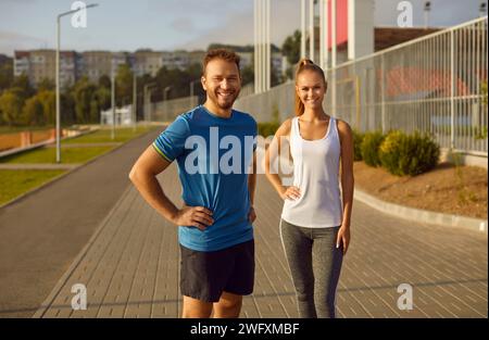Portrait en longueur d'un couple sportif souriant dans Urban Park Banque D'Images