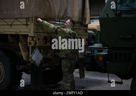 Le spécialiste Carl Finnemore, HHT 2-101 Cavalry, déverrouille le hayon d'un véhicule dans la baie de Buffalo Armory, NY, le 13 janvier 2024. Finnemore et d'autres soldats affectés à la même unité revenaient tout juste d'une course de ravitaillement au centre-ville de Buffalo, face aux intempéries hivernales. Banque D'Images