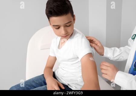 Petit garçon recevant du plâtre après vaccination en clinique Banque D'Images