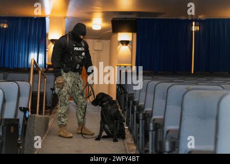 GRANDS LACS, il. (16 janvier 2024) Master-at-Arms 3rd Class Zakery Jackson, de Jacksonville, en Floride, donne des ordres au chien de travail militaire Meeko lors d’une évolution de formation à la détection d’explosifs « kit-pull » à la base navale de Great Lakes, le 16 janvier 2024. L'évolution permet aux chiens et aux maîtres-chiens de s'entraîner à la recherche de matières explosives dans des scénarios réels afin de maintenir leurs compétences et de certifier les MWD. Banque D'Images