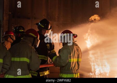 GRANDS LACS, il. (10 janvier 2024) le technicien en chef de Hull Heath Kornack, de Détroit, aide les marins de l'accession au cours de combat de surface Warfare Engineering Schools Command Great Lakes General Shipboard Fire Fighting (GSF) à la base navale de Great Lakes, le 10 janvier 2024. Le programme de deux jours comprend des leçons en classe relatives à la chimie du feu, des classes de feux (alpha, bravo et charlie), l'organisation des pompiers, les extincteurs portatifs, l'équipement de protection, ainsi que l'appareil respiratoire autonome pendant la première journée, et les laboratoires d'entraînement à la lutte contre les incendies en direct couvrent le boyau sauvage, la manipulation du boyau, a Banque D'Images